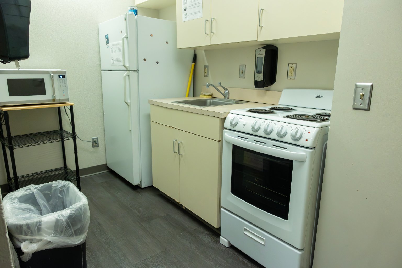 a kitchen with white cabinets and stove