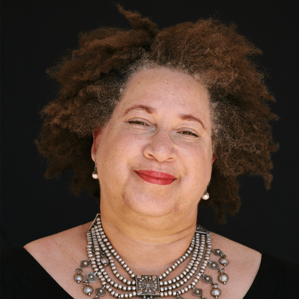 a woman with curly hair wearing a necklace