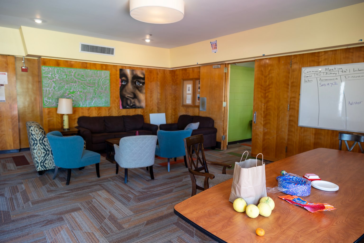 a room with a table and chairs and a bag of food