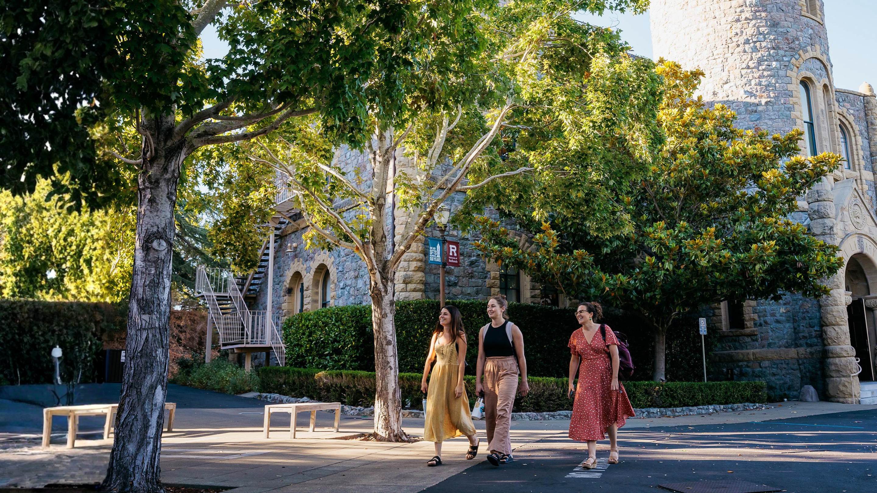 a group of women walking on a sidewalk