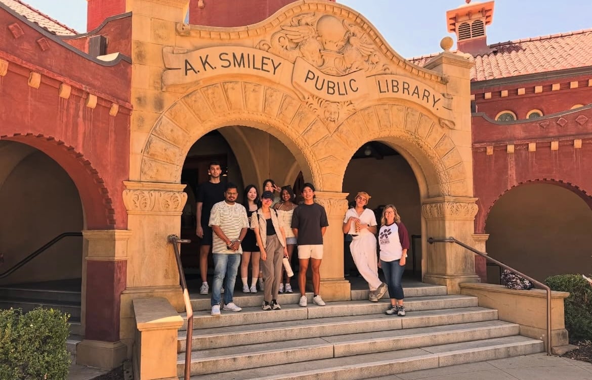 a group of people standing on stairs in front of a library