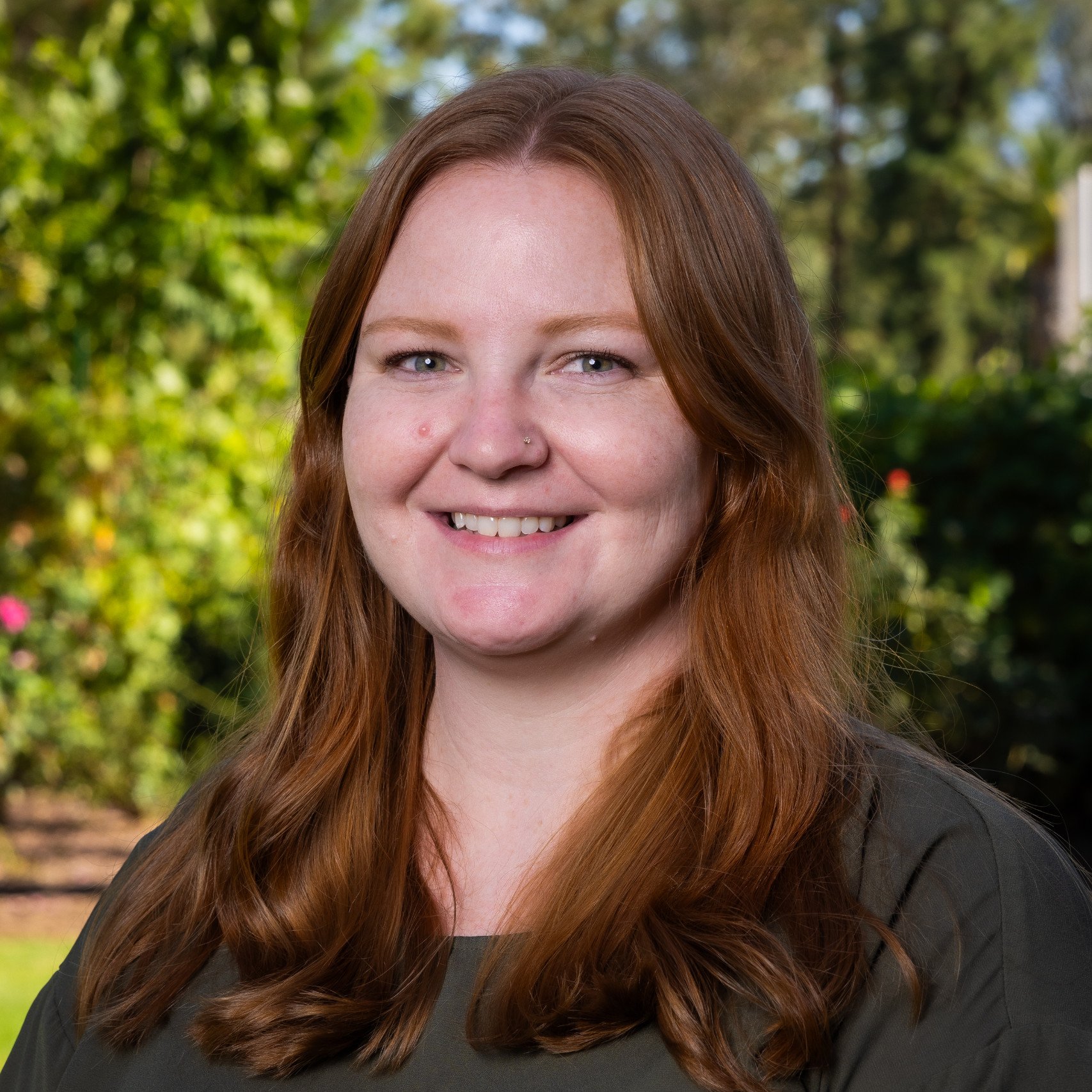 a person with long hair smiling