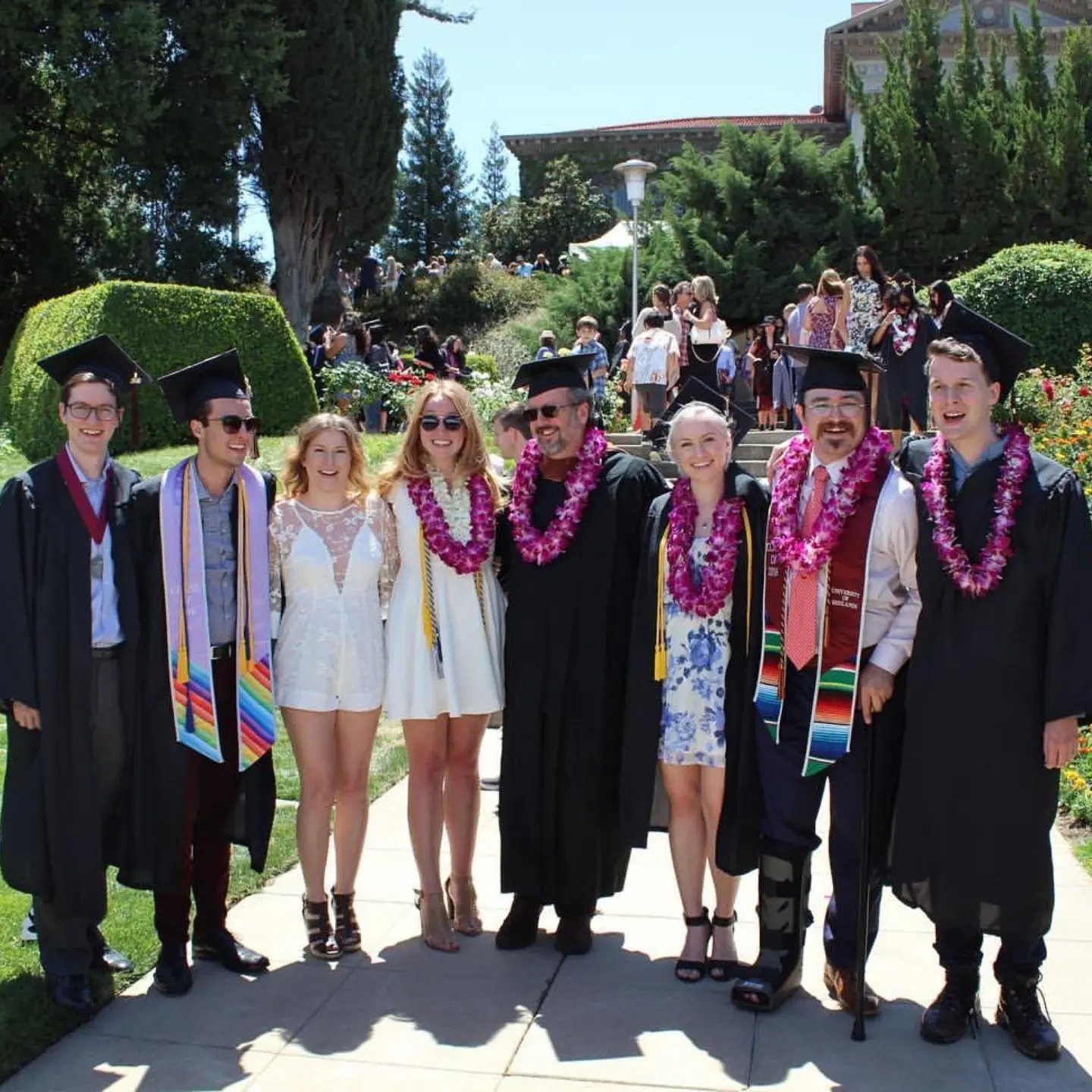 a group of people in graduation gowns and caps posing for a photo