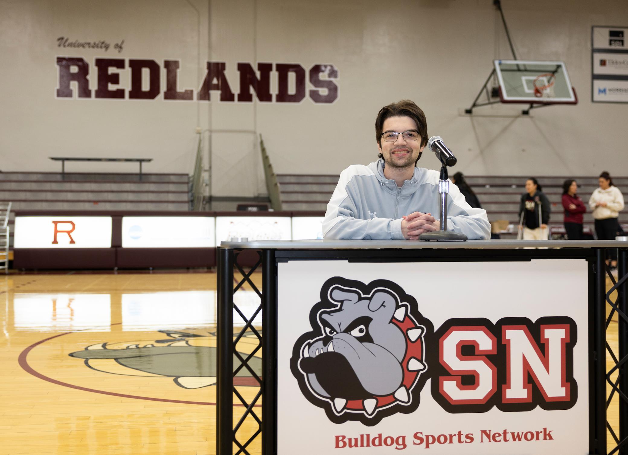 a person standing behind a microphone in a gym