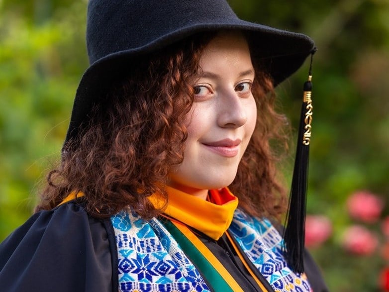 a person wearing a black hat and gown