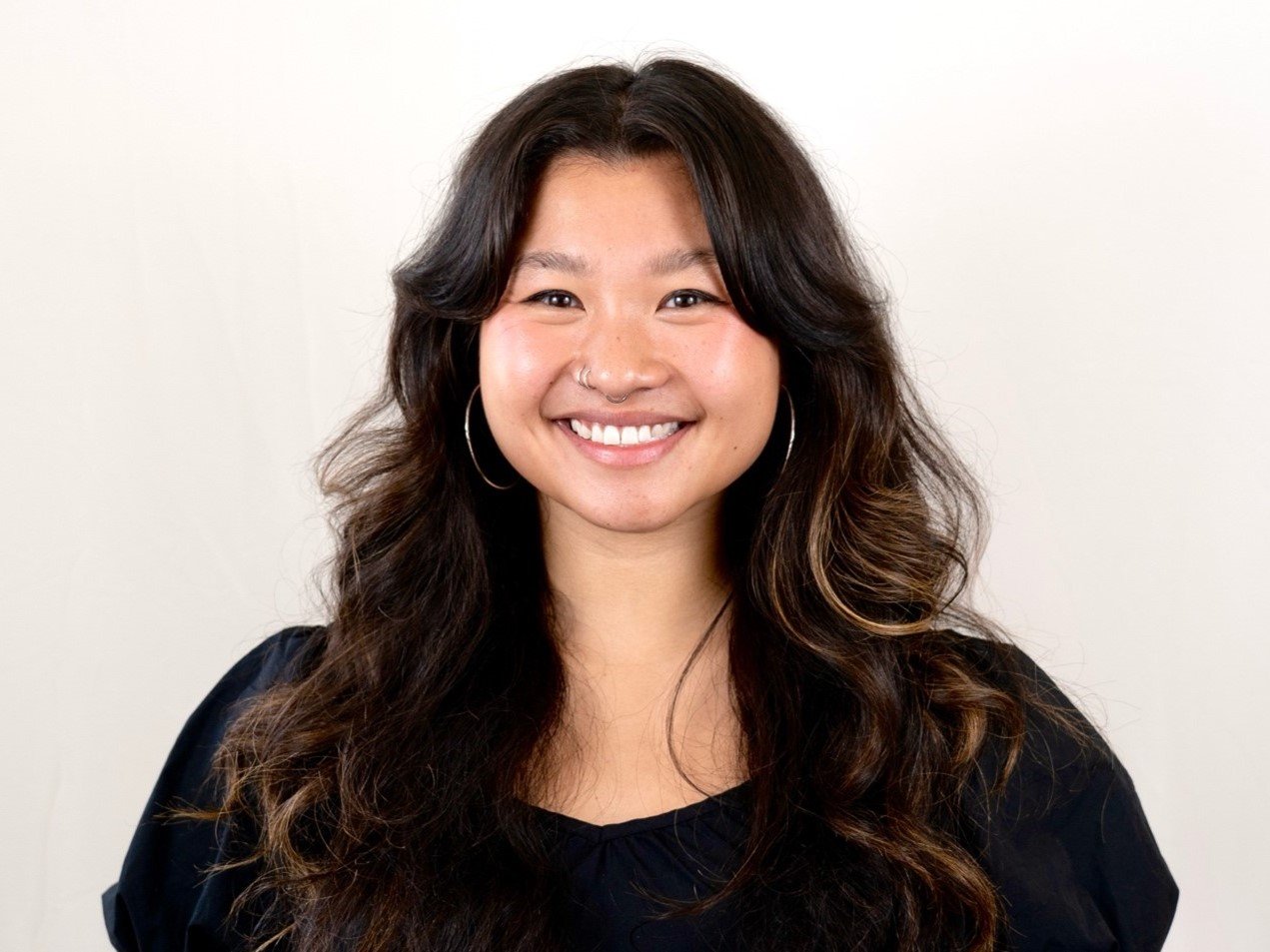 a person with long hair smiling