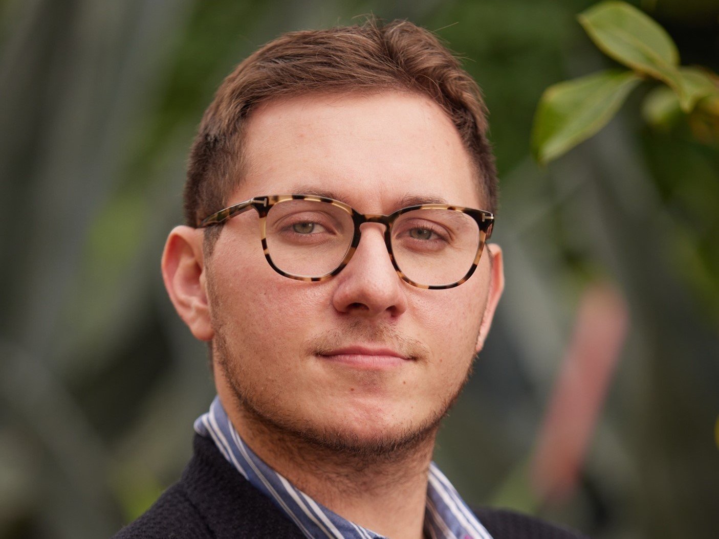 a person wearing glasses and a black jacket