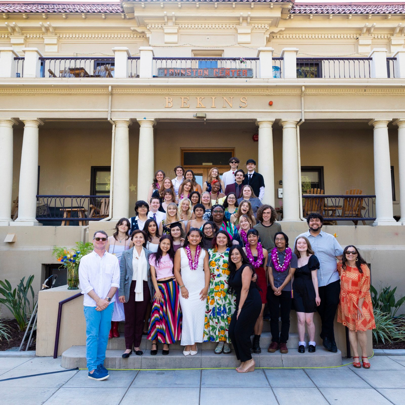 a group of people posing for a photo in front of a building