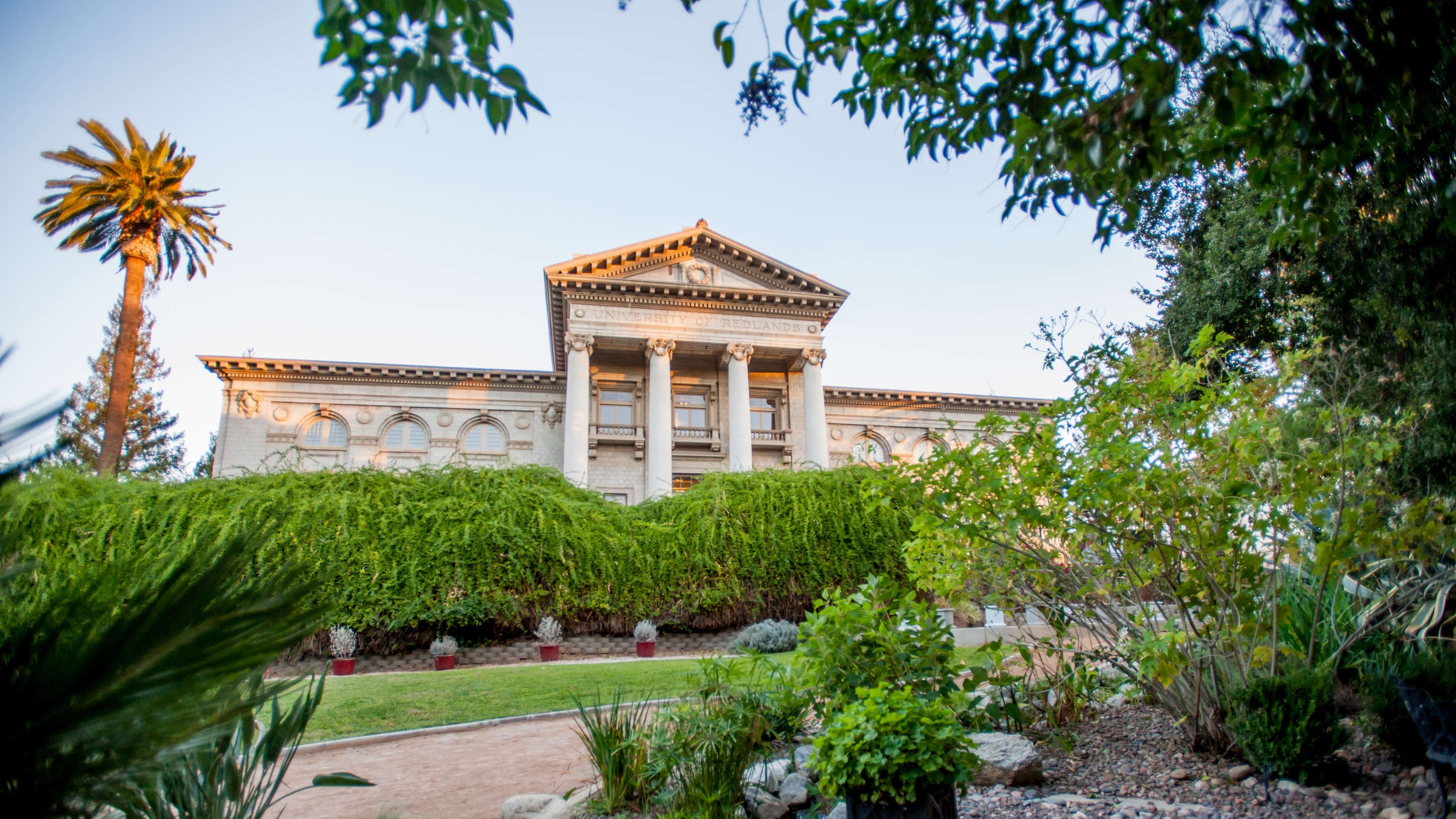 a building with columns and a garden