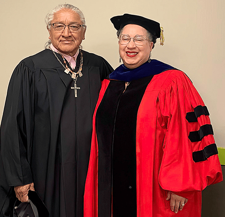 a man and woman wearing graduation gowns