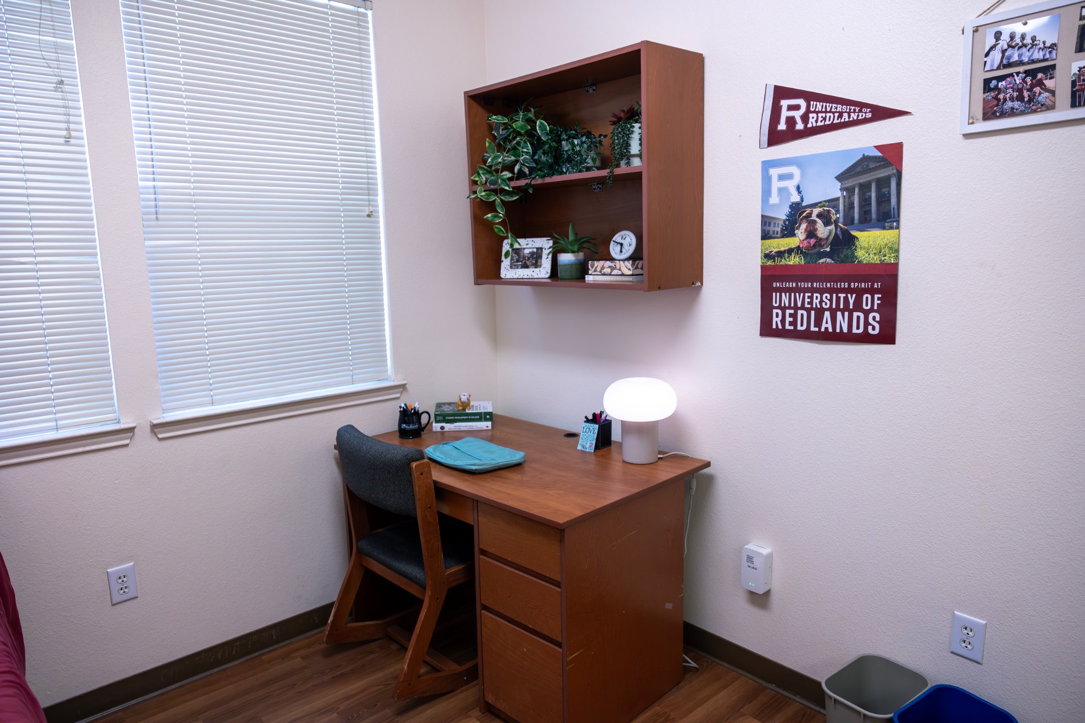 a desk with a lamp and shelves on the wall