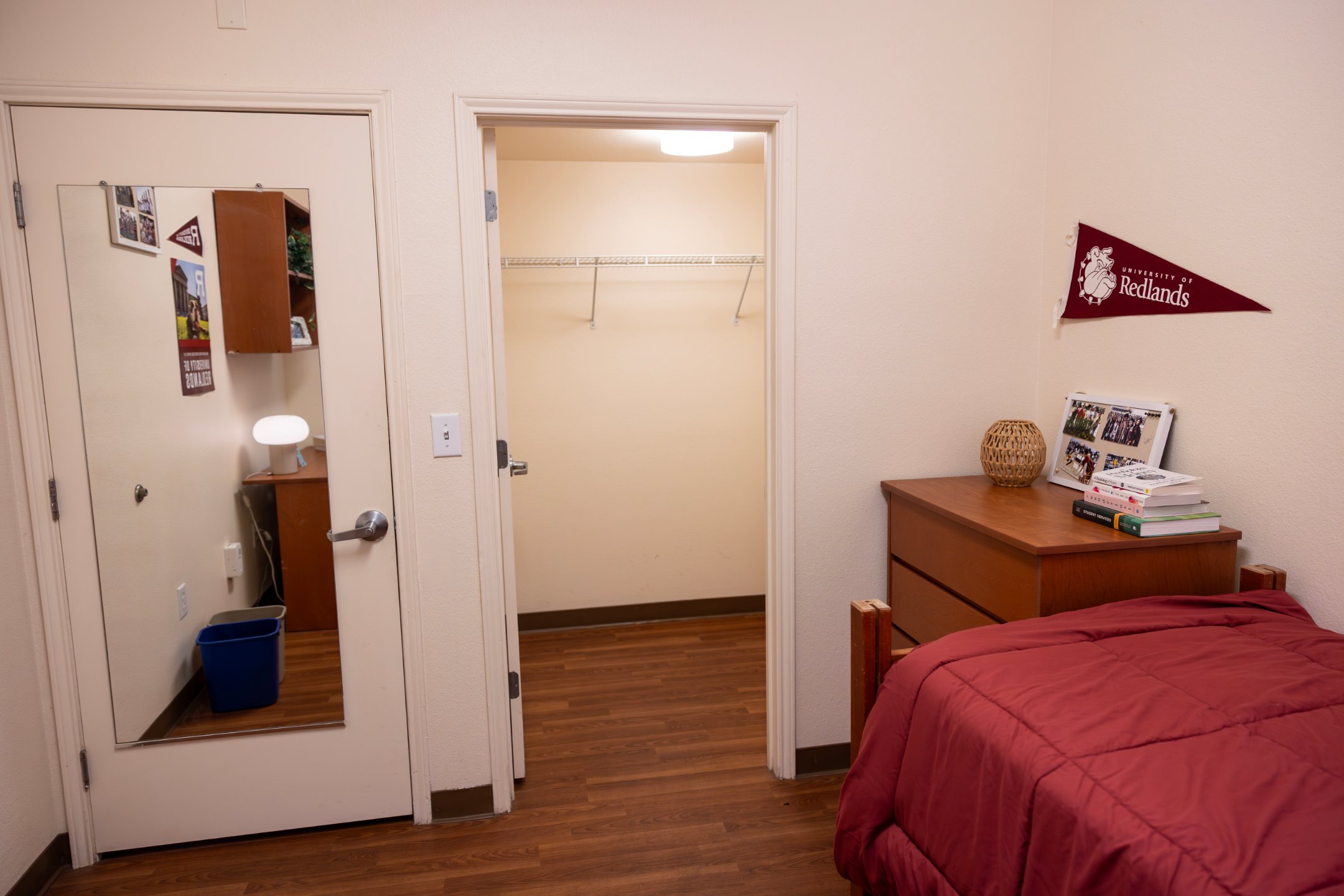 a bedroom with a red bed and a dresser