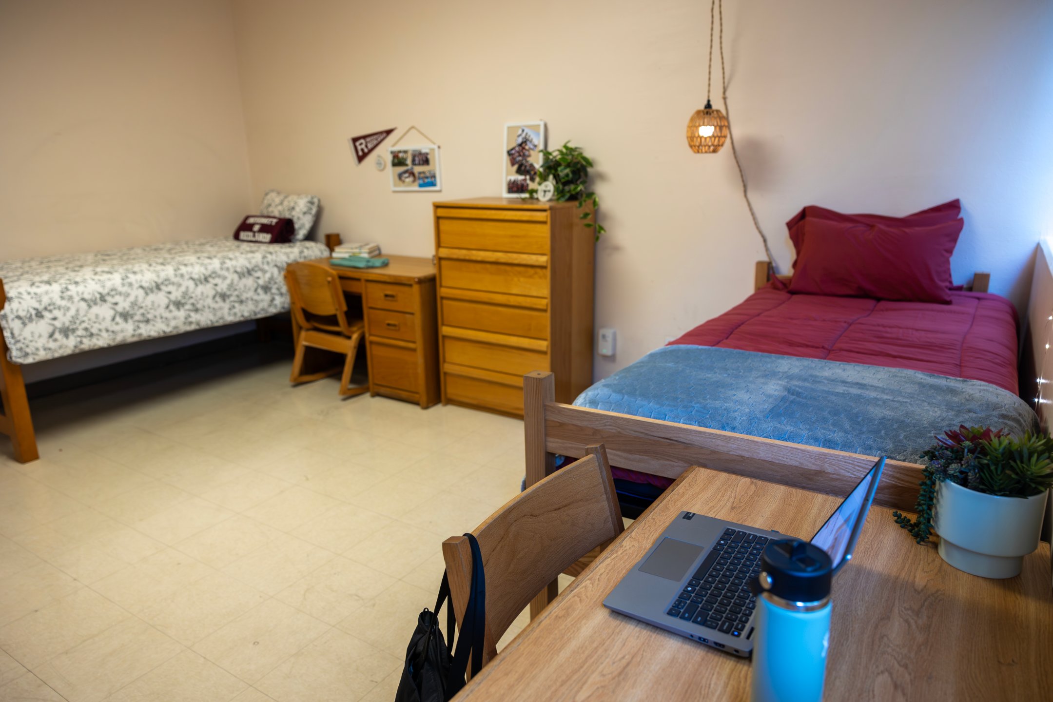 a room with a bed and a laptop on a desk