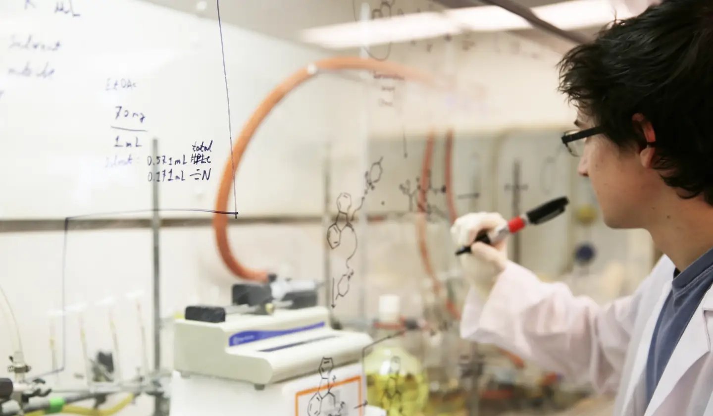 a person writing on a glass wall