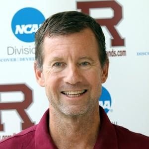 a person smiling in front of a sign