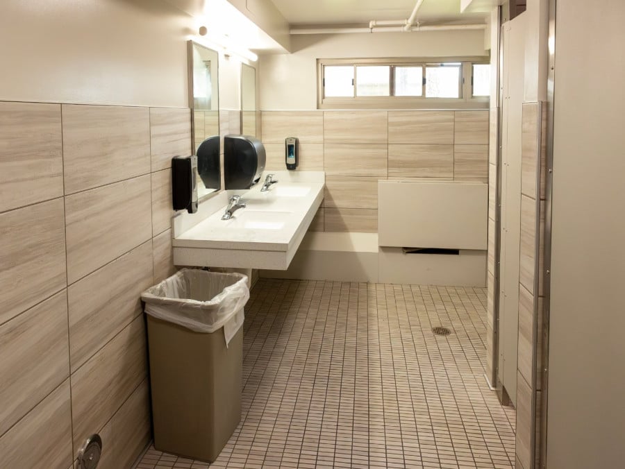 a bathroom with a sink and a trash can