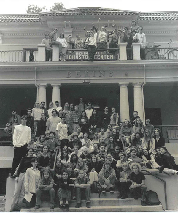 A group of students stands in front of Bekins Hall with a sign that says Johnston Center