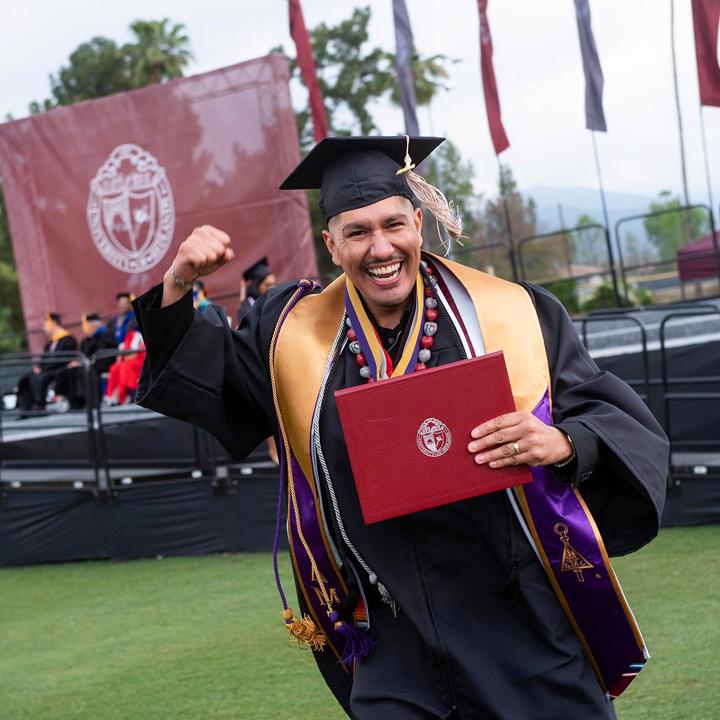 School of Business graduate celebrating receiving their diploma.