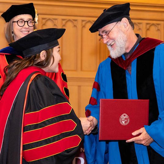 Theology graduate student receiving diploma at seminary graduation.